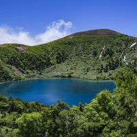 登山道の茂みから見るカルデラ湖（魔女の瞳）の写真