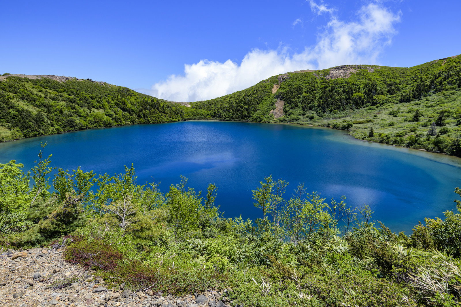 真っ青な水を携えたカルデラ湖（魔女の瞳）と周囲の緑豊かな山々