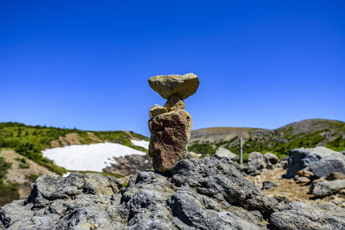 快晴の空に映える積み上がるケルン（積み石）の道標