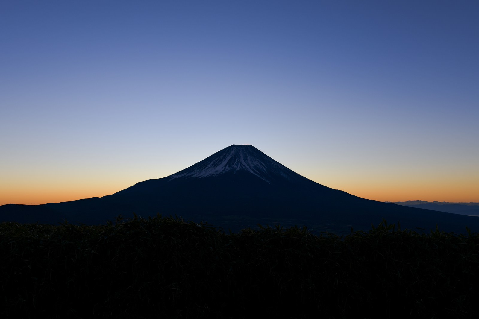 竜ヶ岳から見た夜明け前の富士山のシルエットと朝焼けの空
