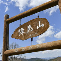 陣馬山の山頂標と青空の写真