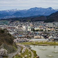 舞鶴山から俯瞰する天童市内と雪を頂いた奥羽山脈の写真