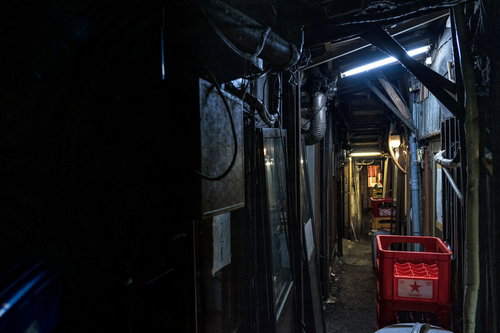 荒れ果てた飲み屋の裏路地と赤い看板