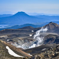 火口から噴煙吹き上げる雌阿寒岳と雄阿寒岳の写真