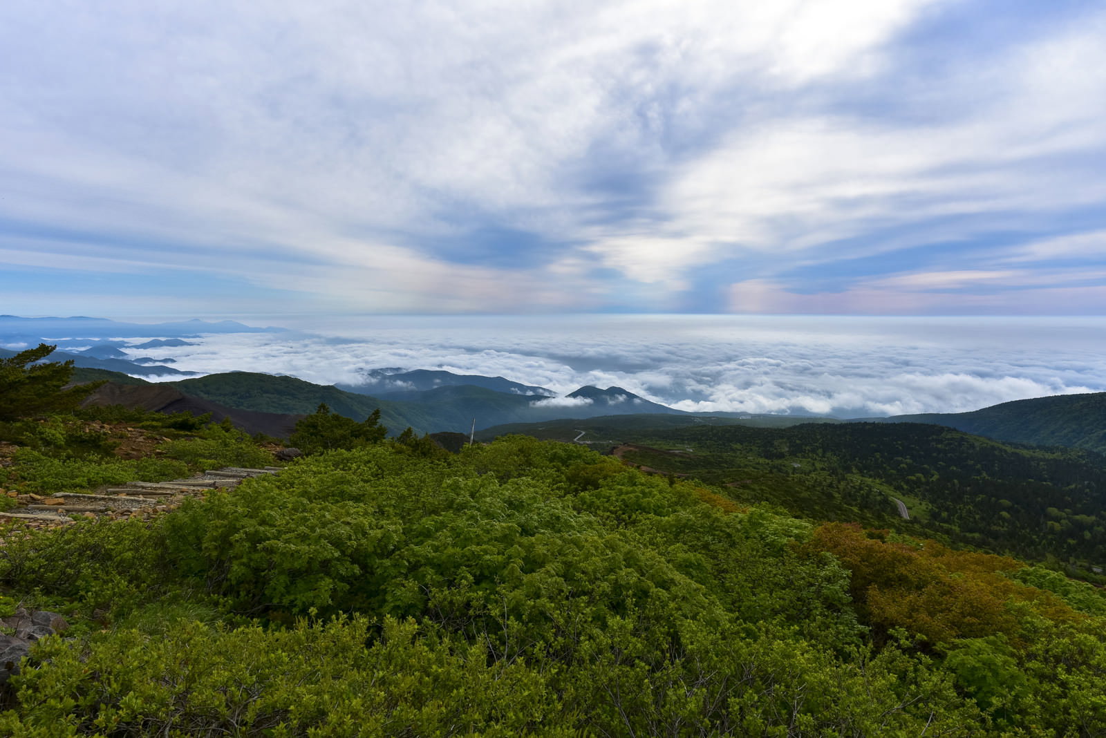 雲海に囲まれた蔵王の登山道と緑豊かな山々の稜線