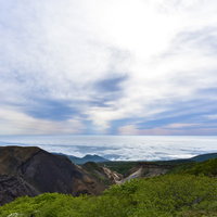 雲海と上層雲に挟まれた蔵王連峰の山々の写真