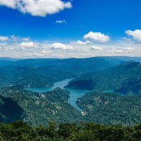 浅草岳から見る守門岳と田子倉ダム、青い湖を望む福島県の山間風景の写真