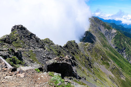 雲に包まれる北岳の険しい稜線と登山道、日本百名山の岩場風景