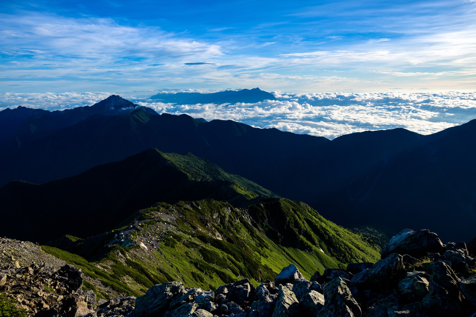 雲海に包まれた南アルプスの山々を山頂から見下ろした景色