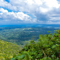 登山中の嘉津宇岳から見た沖縄の街並みと海岸線の写真
