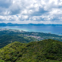 沖縄県の嘉津宇岳から見る名護の街並みと青い海の写真