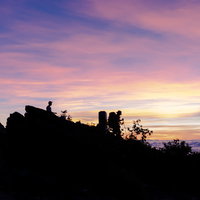 千枚岳の山頂で朝日を拝む登山者達のシルエットの写真