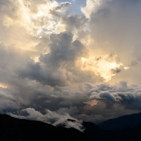 夕日の光と神々しい下層雲が山を照らす南アルプスの写真