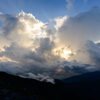 南アルプスの雲の中から溢れ出る太陽の光と山々の写真