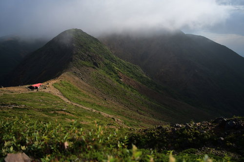 朝靄に包まれた那須岳避難小屋と稜線の雲海風景