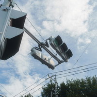 歩道から見上げる信号機と青空の写真