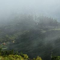 雲と霧に包まれゆく巻機山避難小屋の朝景色の写真