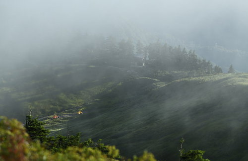 雲と霧に包まれゆく巻機山避難小屋の朝景色