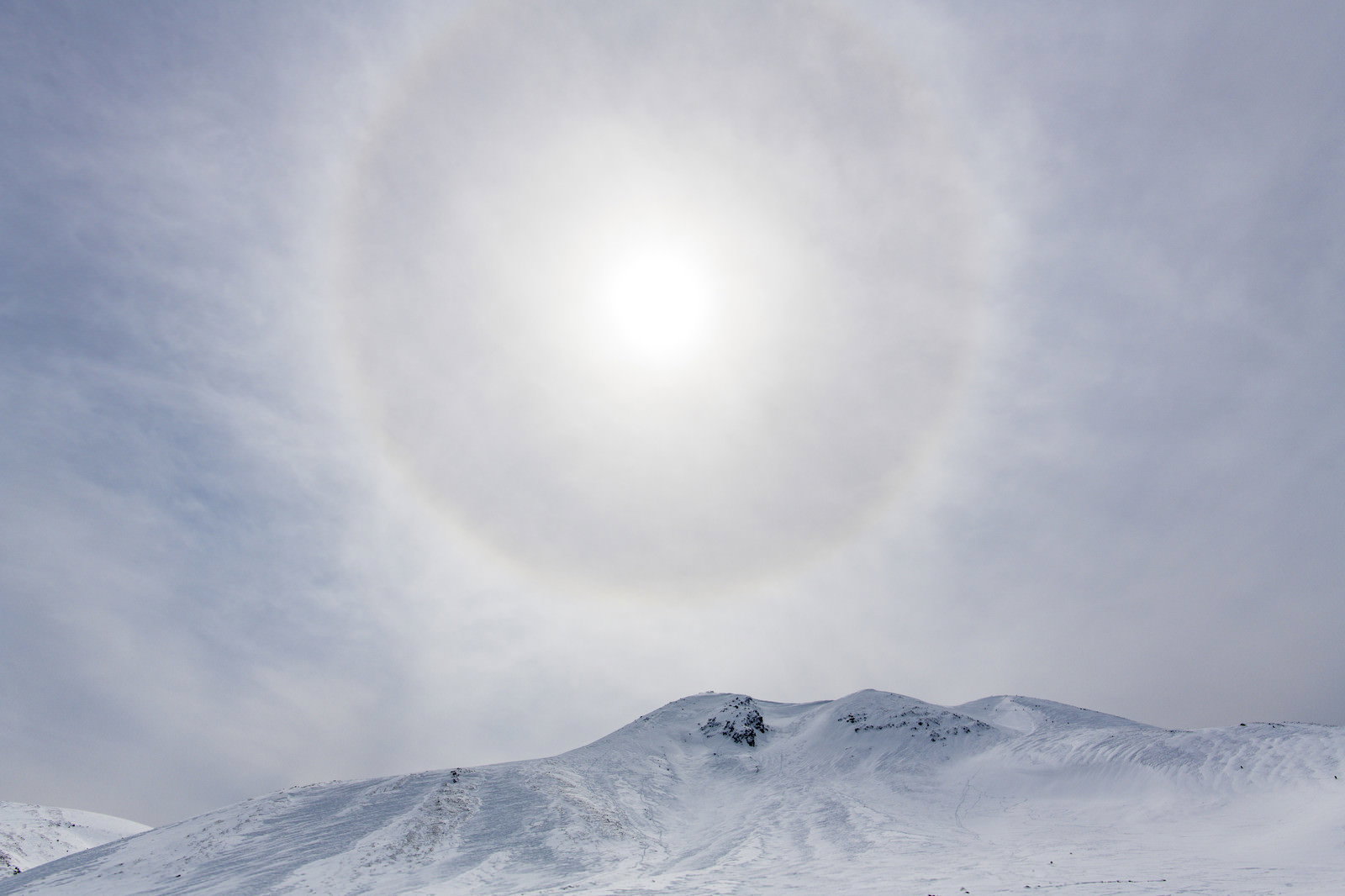 乗鞍岳の雪山上空に現れた虹色のハロ（日暈）