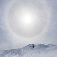 乗鞍岳の雪山にかかる虹色の光の輪（ハロ）の写真