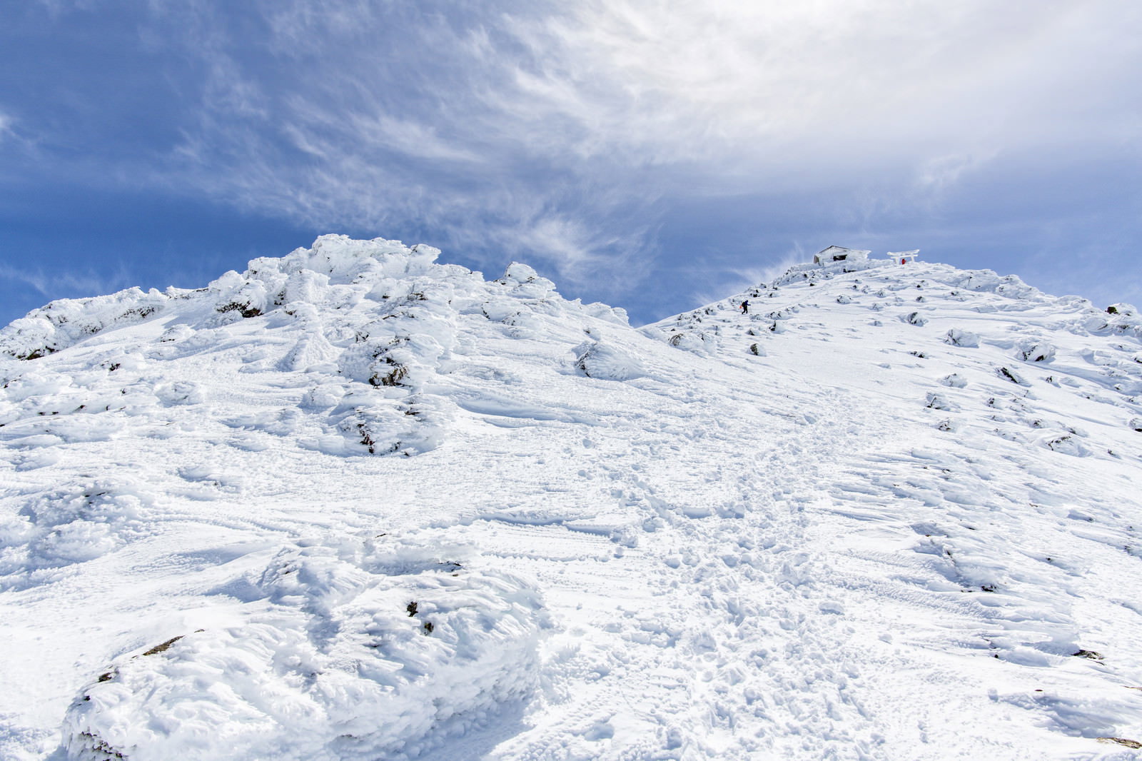 雪に覆われた乗鞍岳の山頂部分と青空が広がる冬山の風景