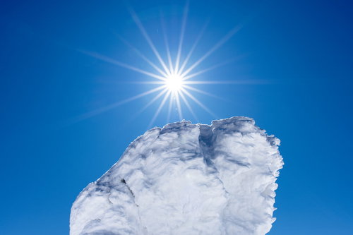 青空に輝く光芒と樹氷に覆われた木々の冬景色
