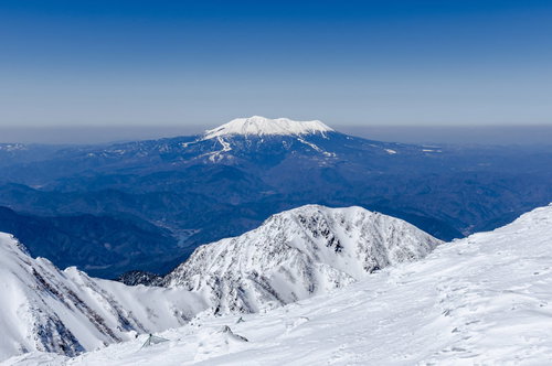 青空に映える冠雪する御嶽山の雪山風景