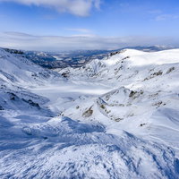 雪に埋もれた安達太良山の爆裂火口と冬の火山地形の写真