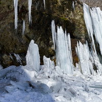 岩壁から崩れ落ちた氷柱と積雪、凍結した冬景色の写真