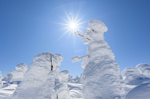 巨大なスノーモンスターと太陽の光芒が輝く雪山