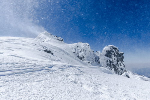 木曽駒ヶ岳の斜面で強風に舞い上がる積雪と冬山の自然