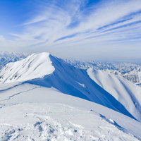 茂倉岳方面の雪景色と青空が広がる冬山の風景の写真