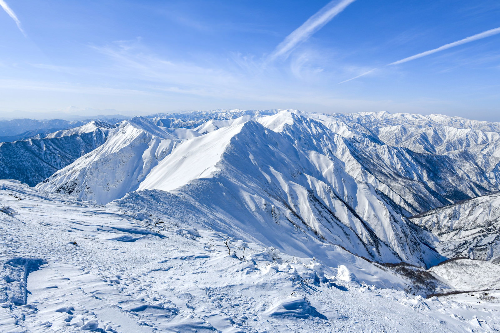 青空の下、雪化粧した谷川岳主脈の山々が連なる冬の雪景色