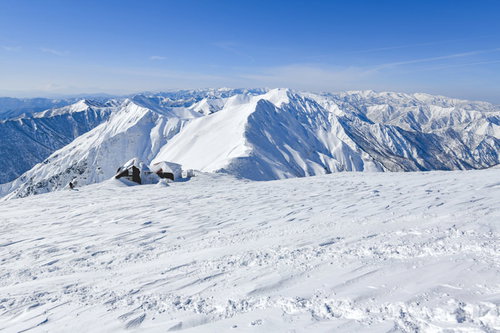 雪に包まれた谷川岳肩の山小屋と主脈の冬景色