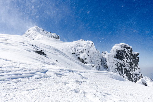 風雪舞う宝剣岳の険しい岩峰（木曽山脈）冬の雪山