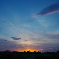 夕焼けが地平線に沈む最後の一瞬と青空のグラデーションの写真