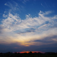 焼ける地平と真っ青な空の夕焼け風景、薄暮時の雲と光の写真