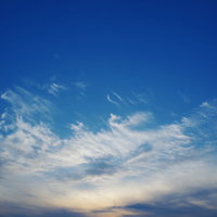 真っ青な空に広がる白い雲と夕日の風景、地平線の写真