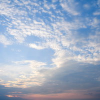 パステルカラーに染まる夕焼けの青空と白い雲の写真
