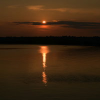 凪の海に沈みゆく太陽とレイラインの写真
