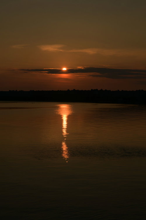 凪の海に沈みゆく太陽の夕景～水面に映る光線のレイライン