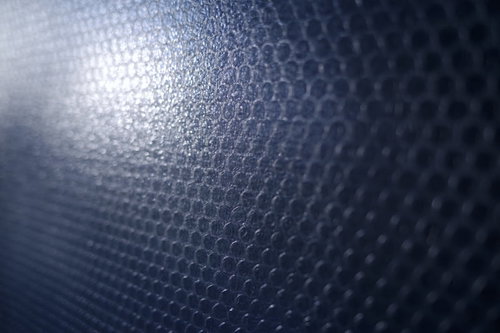 壁一面を覆う透明な緩衝材とプチプチの気泡クッション