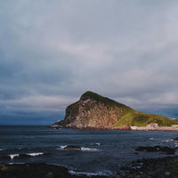 夕日に染まるペシ岬（利尻島）の海岸線と夕焼け風景の写真
