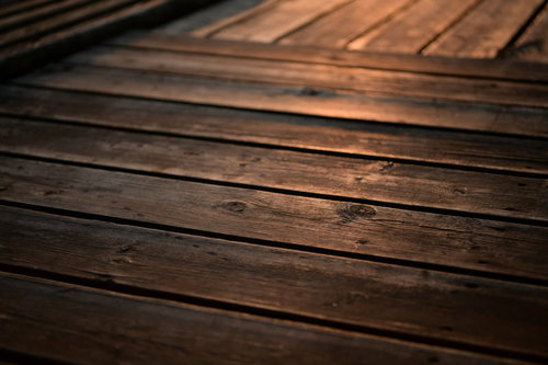 夕日が照らすウッドデッキの木目と板張りの質感