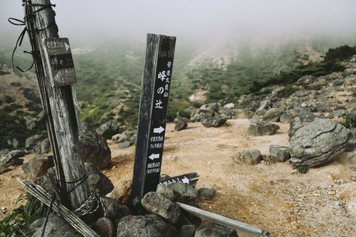 安達太良山の峰の辻に立つ複数の木製指導標