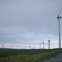 宗谷丘陵近くで稼働する風力発電の風車郡と発電施設の写真