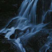 岩に打ち付ける清流の白い水飛沫と渓流の流れの写真