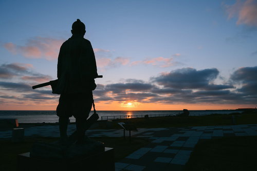 樺太を見つめる間宮林蔵像と夕焼け空