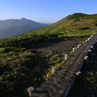 稜線を伝う立派な木道と青空の写真