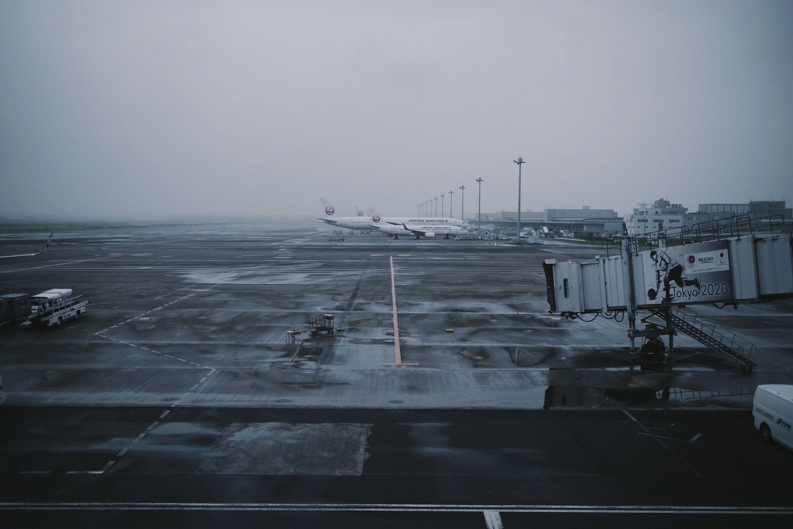 曇り空の下、羽田空港の滑走路に駐機している複数の飛行機